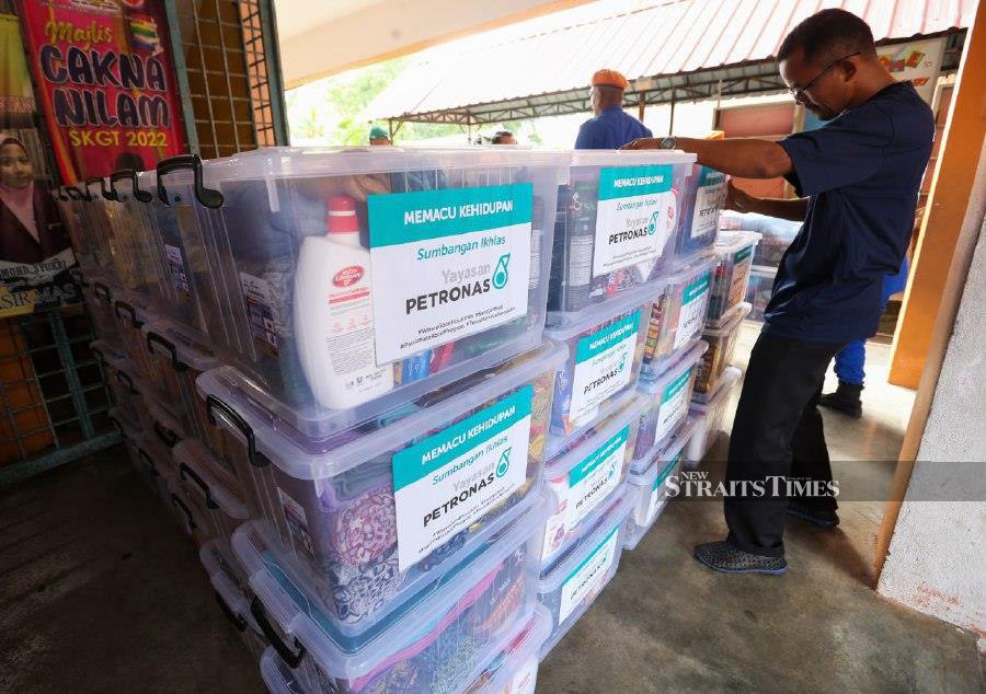 Petronas handed its 'Prihatin Pakej' to 1,500 victims in Kelantan who were affected by flood. -NSTP/NIK ABDULLAH NIK OMAR