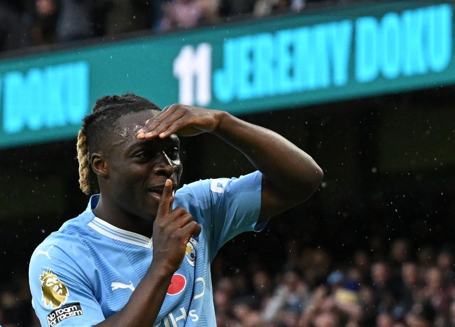 Manchester City's Belgian midfielder #11 Jeremy Doku celebrates scoring the opening goal during the English Premier League football match between Manchester City and Bournemouth at the Etihad Stadium in Manchester, north west England. -AFP/Paul ELLIS