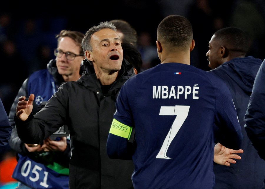 Paris St Germain's Kylian Mbappe celebrates with coach Luis Enrique after the match. -REUTERS/Vincent West