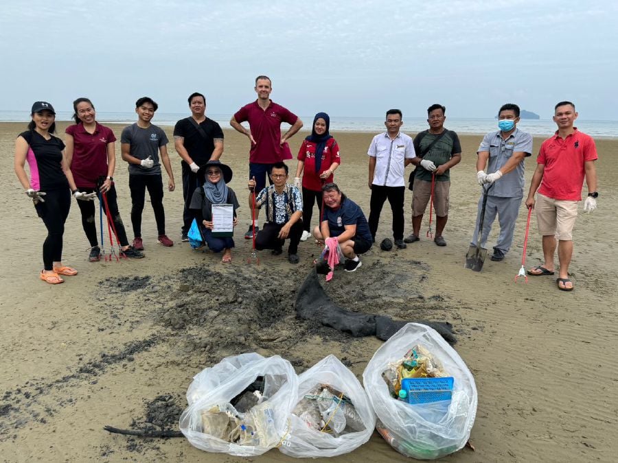 Reef Check, resort personnel and media taking part in beach clean-up in Tanjung Aru. -COURTESY PIC