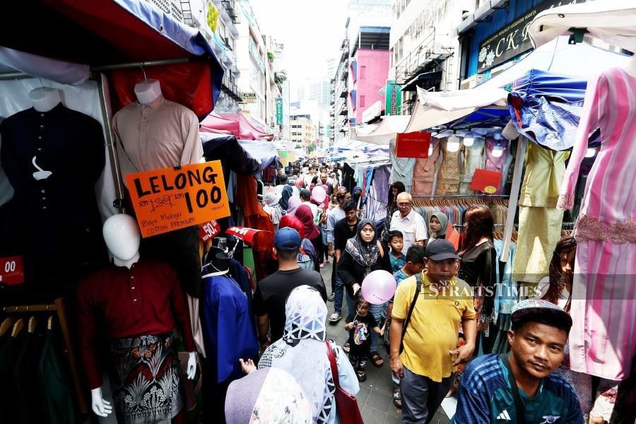 Businesses are seen offering promotions such as three baju kurung for RM100 and other out-of-this-world discounts at Jalan Tunku Abdul Rahman market. -NSTP/SAIFULLIZAN TAMADI