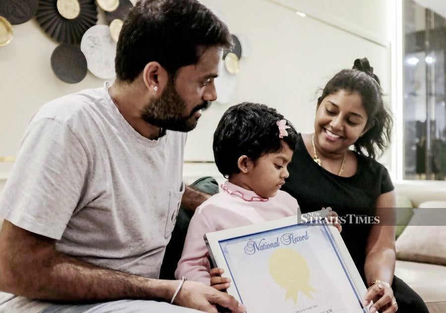 Jeimithra Vasagam, 3, with her mother Dr Mathi Vathani, and her father, Manickavasagam with her world record certificate. -NSTP/SADIQ SANI