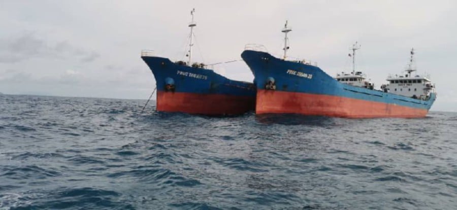 The Malaysian Maritime Enforcement Agency detained two Vietnamese-registered cargo vessels for illegal anchoring off Pulau Pemanggil. Also detained were the vessel captains and its chief engineers. -PIC COURTESY OF MMEA MERSING MARITIME ZONE