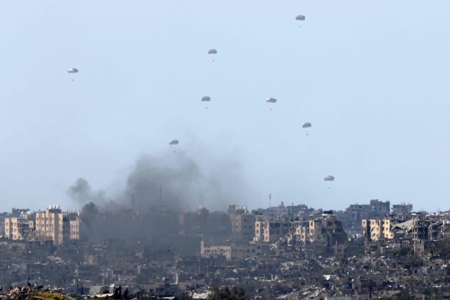 Humanitarian aid falls over northern Gaza as seen from Israel's southern border with the Gaza Strip. -AFP/JACK GUEZ