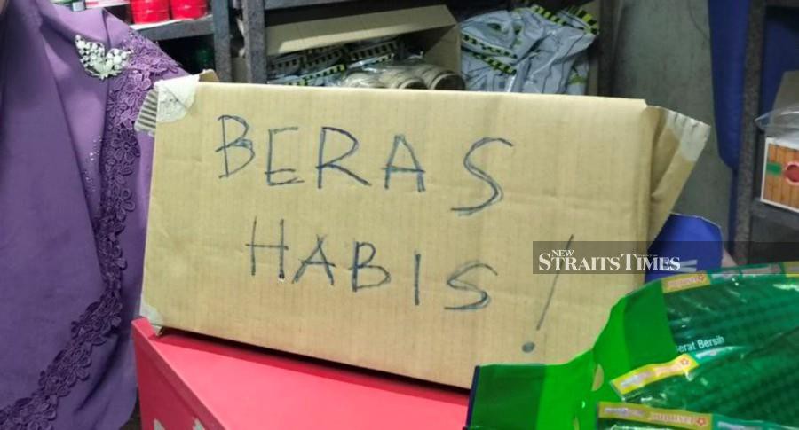 A trader puts up a notice after running out of rice, at a shop in Pasar Besar Alor Star.