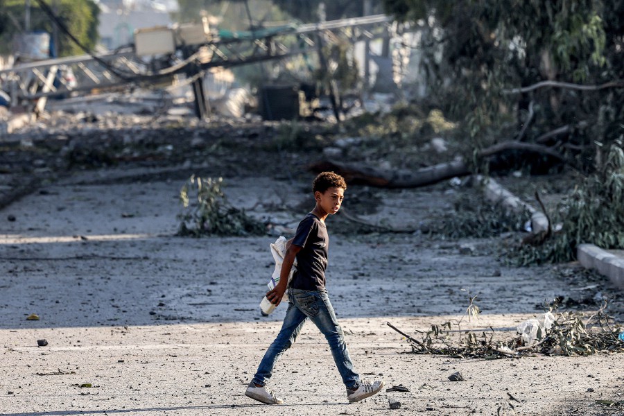 A boy walks across a street past felled trees and destroyed structures in Gaza City. It is imperative that the ICC issues a stern warning, making it unequivocally clear that while Israel has a right to defend itself, crimes against humanity and war crimes must not be tolerated. -AFP/MOHAMMED ABED