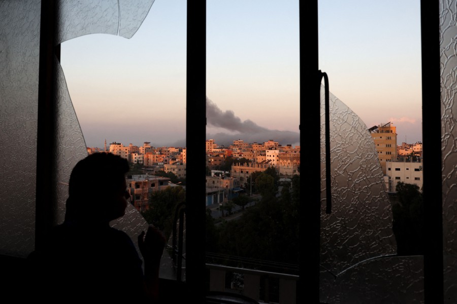 A Palestinian child watches as smoke billows on the horizon after an Israeli air strike in Gaza City on October 13, 2023. Israel has called for the immediate relocation of 1.1 million people in Gaza amid its massive bombardment with the United Nations warning of "devastating" consequences. -AFP/MOHAMMED ABED