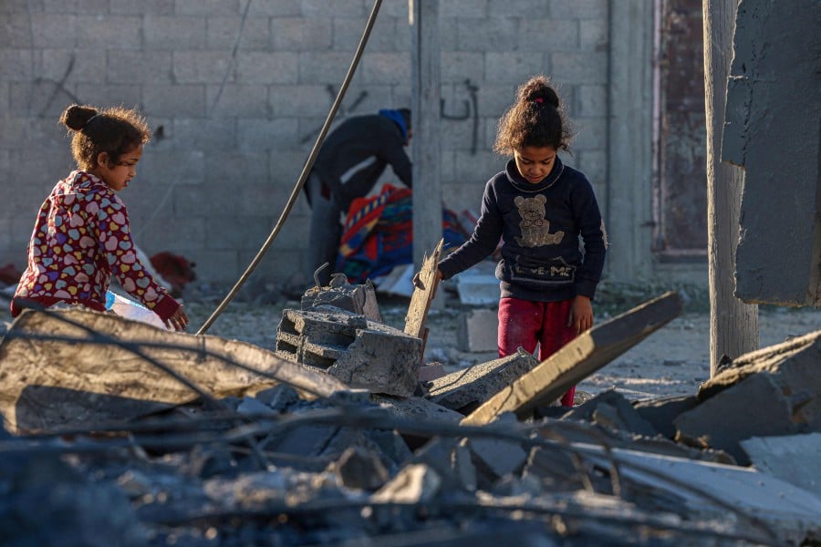 Children check the rubble following Israeli bombardment in Rafah in the southern Gaza Strip. -AFP PIC