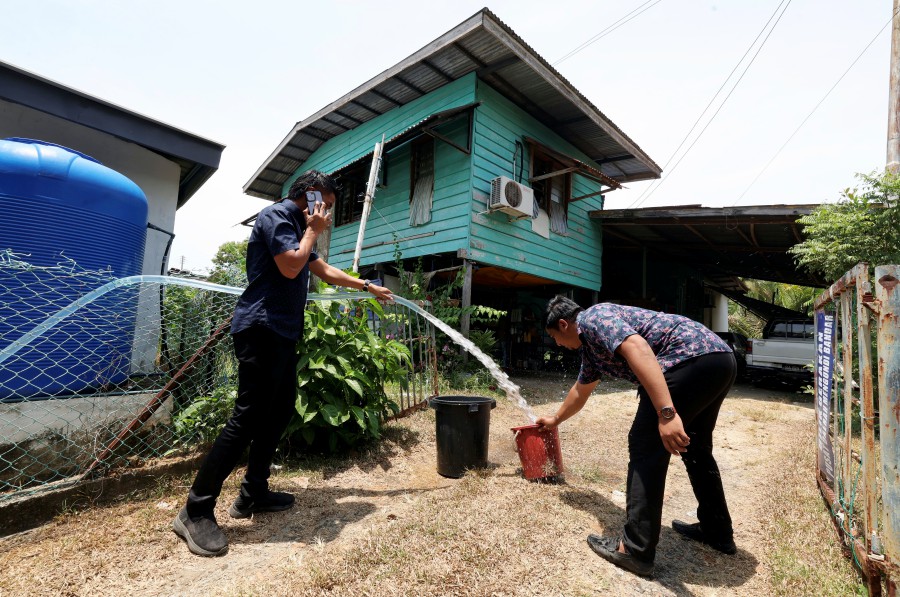 Papar Member of Parliament Office employees assist local communities by giving clean water at Kampung Kuala Papar. Papar activated its disaster operation centre here following a severe water supply issue. -BERNAMA PIC