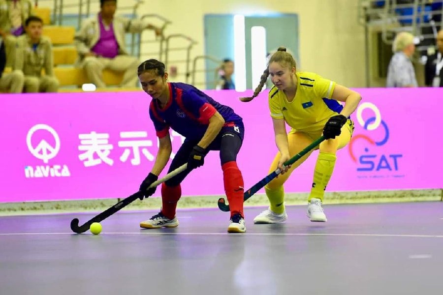 Malaysia (in blue) in action against Kazakhstan in a women’s Indoor Hockey Asia Cup match today. -PIC COURTESY OF MHC