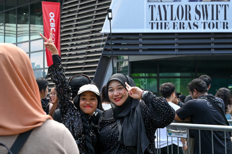 Fans of US singer Taylor Swift, also known as Swifties, take photos as they arrive for the pop star's Eras Tour concert at the National Stadium in Singapore. Contrary to reports, her concert was never offered to Malaysia. -AFP/Roslan RAHMAN