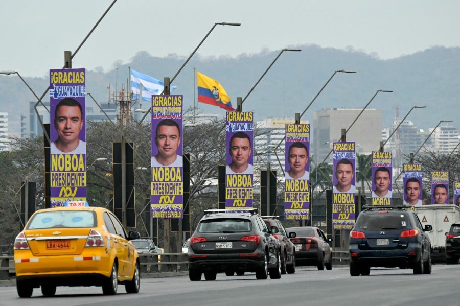 Cars drive along a bridge decorated with advertisements for Ecuador's presidential candidate of the National Democratic Action Party, Daniel Noboa, in Guayaquil, Ecuador. Leftist frontrunner Luisa Gonzalez and challenger Daniel Noboa will face in the October 15 runoff election. -AFP/Rodrigo BUENDIA
