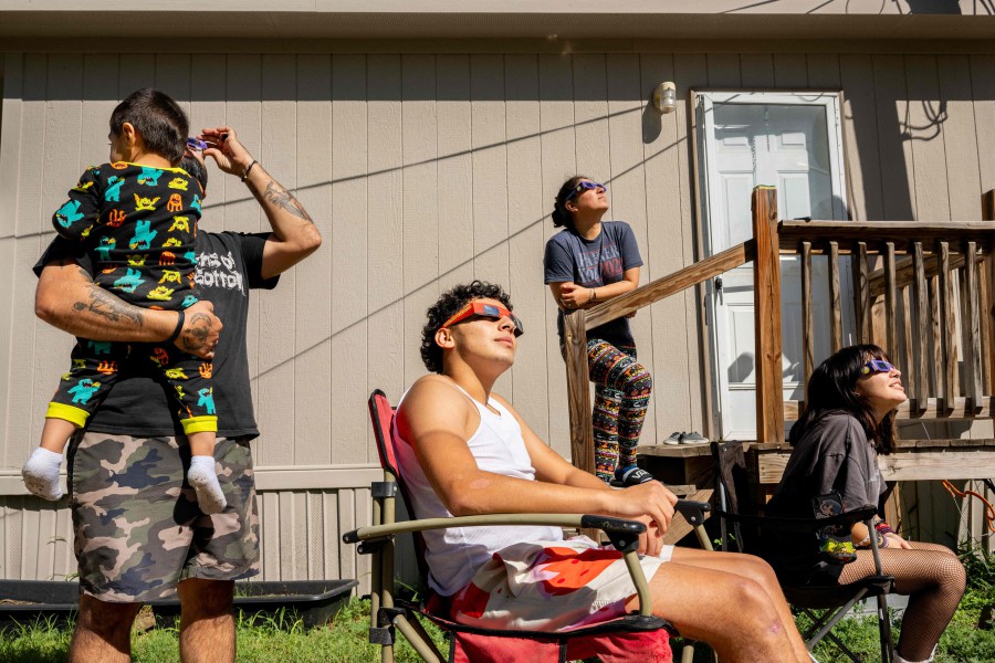 The Flores family watches the annular solar eclipse together in Kerrville, Texas. Differing from a total solar eclipse, the moon in an annular solar eclipse covers part of the sun's light, creating the "ring of fire" effect around the moon. -AFP/Brandon Bell