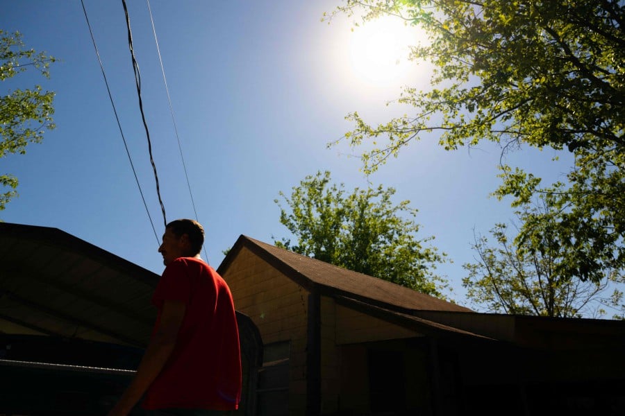 Scott Eric Schindler watches the annular solar eclipse from his backyard. -AFP/Brandon Bell