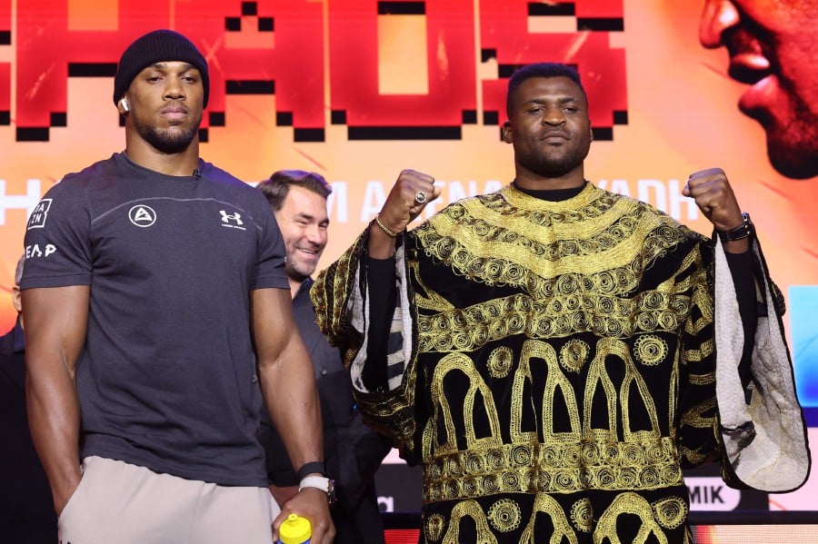 British heavyweight boxer Anthony Joshua (left) and French-Cameroonian boxer Francis Ngannou (right) pose after a press conference in London ahead of their fight in March. -AFP/Daniel LEAL