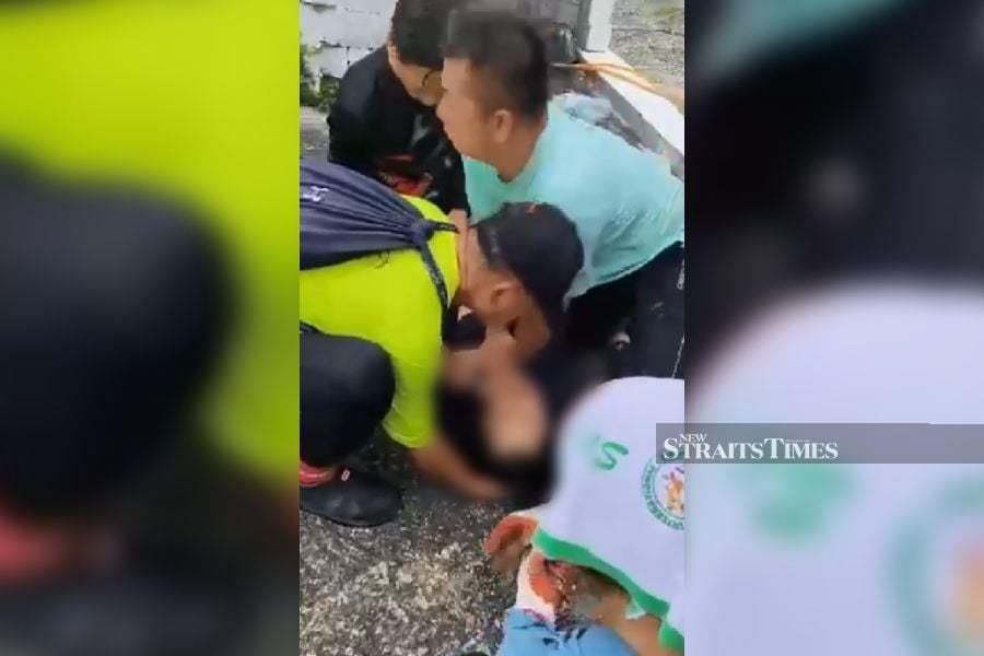 A snapshot from a 10-second video showing people performing CPR on a woman who was stung by bee while trekking at Bukit Gambir in George Town, Penang. 