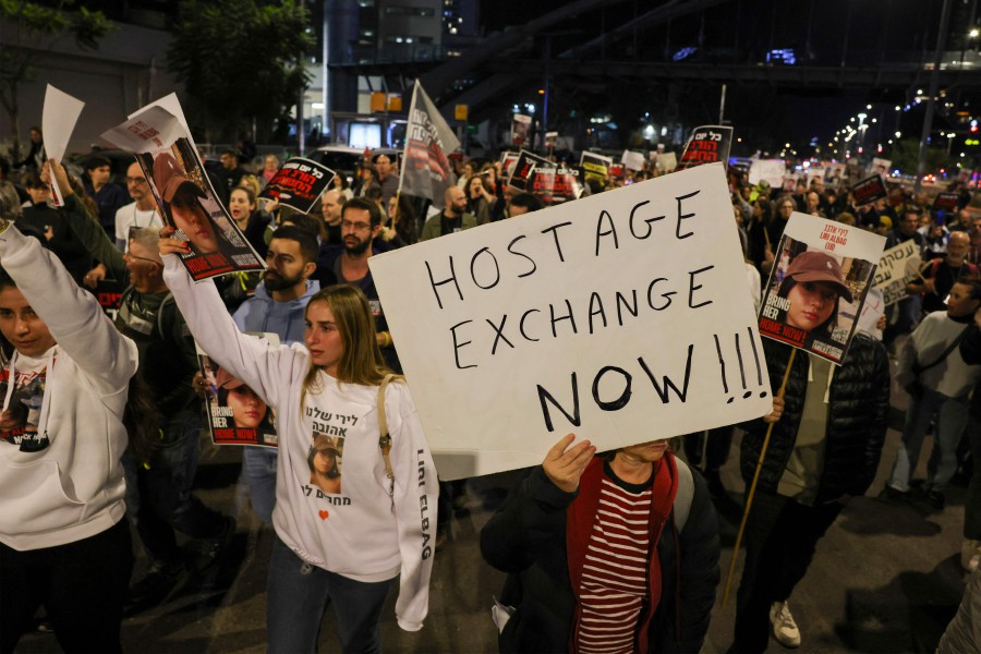 Families and supporters of hostages hold demonstration outside the Israeli ministry of defence in Tel Aviv, calling for an immediate deal or their release in exchange for Palestinian prisoners. The Israeli army said its troops shot and killed three Israeli hostages on December 15 in Shejaiya (a battleground neighbourhood of Gaza City), after "mistakenly" identifying them as a threat. -AFP/AHMAD GHARABLI