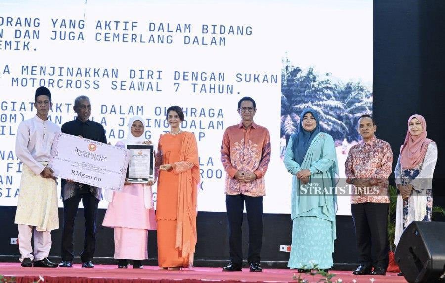 Nur Alya Damia Mohd Faisal (third from left) was honoured with a Children’s Special Award at the state-level World Children’s Day, Persons with Disabilities Day and Elderly Citizens Day at Raia Hotel and Convention Centre. -NSTP/AHMAD MUKHSEIN MUKHTAR