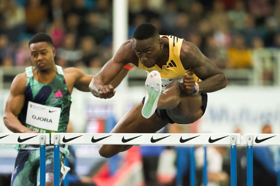 (FILE PHOTO) US' Grant Holloway competes in the 60m hurdles men at the Athletics meeting. Hurdles king Grant Holloway set a new world record as he blasted into the final of the 60-metre hurdles at the US Indoor Championships in New Mexico on February 16, 2024. -AFP/DENIS CHARLET