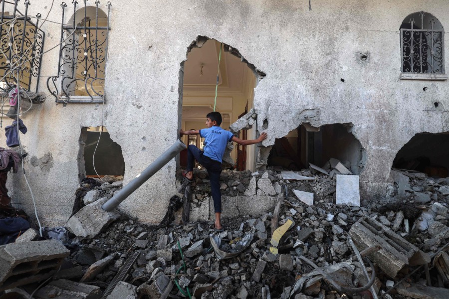 A Palestinian boy enters a building destroyed by Israeli bombardment the previous night in Rafah the southern Gaza Strip on April 17, 2024. -AFP/MOHAMMED ABED