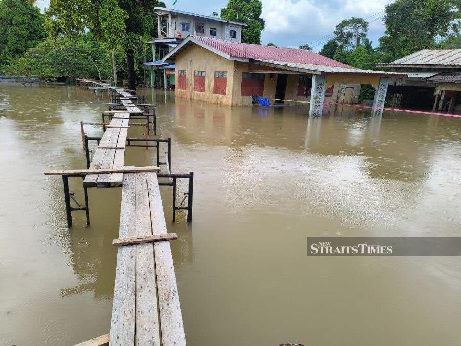 Flood victims in several villages in Rantau Panjang build ‘bridges’ connecting their flooded homes to the main road to make it easy for them to move during the monsoon season. -NSTP/SHARIFAH MAHSINAH ABDULLAH