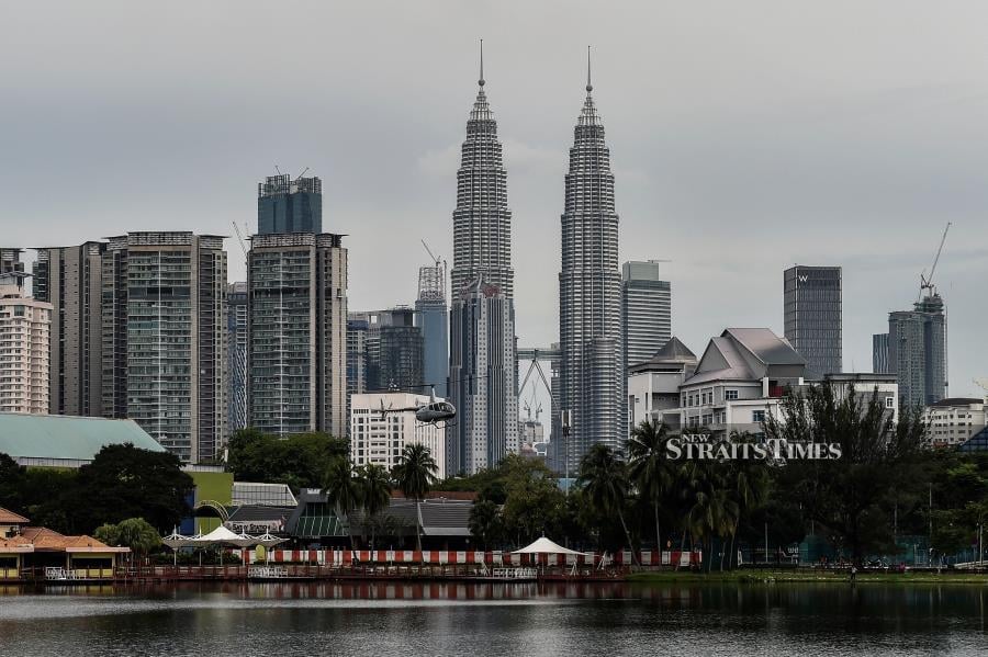 Malaysia's iconic landmark Petronas Twin Towers (C) domninates the skyline of Kuala Lumpur. (Photo by Mohd RASFAN / AFP)
