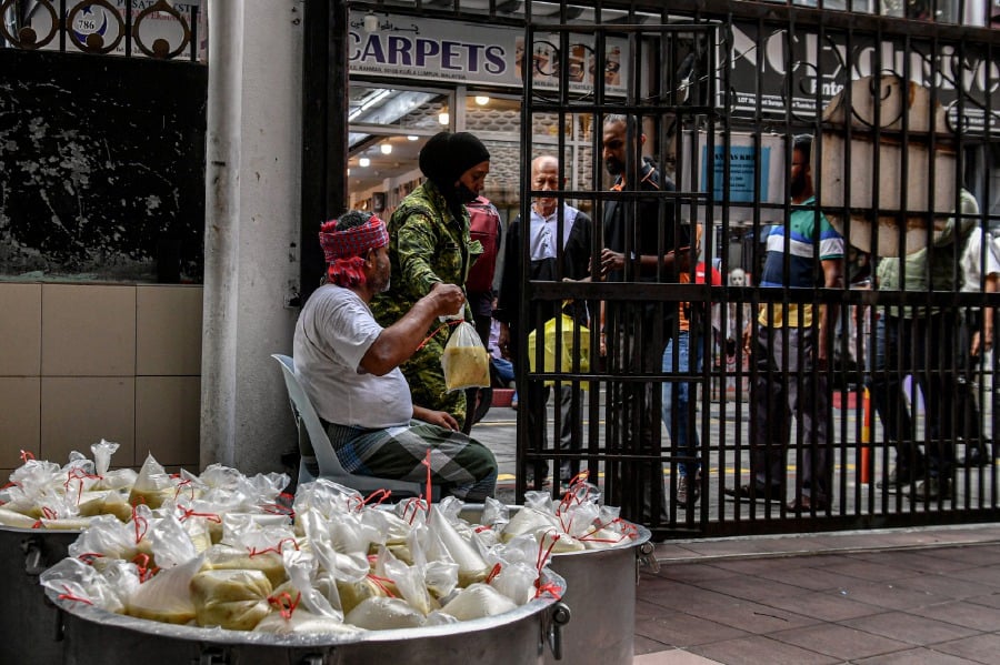 KUALA LUMPUR: Mosque officials at the Masjid India in Jalan Tuanku Abdul Rahman distribute porridge to the public during the month of Ramadan. -BERNAMA PIC