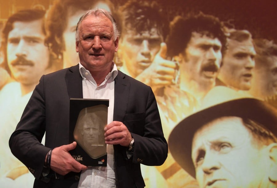 (FILE PHOTO) Former German football player Andreas Brehme holds his trophy as he attends the opening gala for the Hall of Fame of German Football at the German Football Museum. Andreas Brehme, who scored from the penalty spot to seal victory for West Germany against Argentina in the 1990 World Cup final, died overnight into February 20, 2024 at the age of 63, his former club Bayern Munich said. -AFP/Ina FASSBENDER