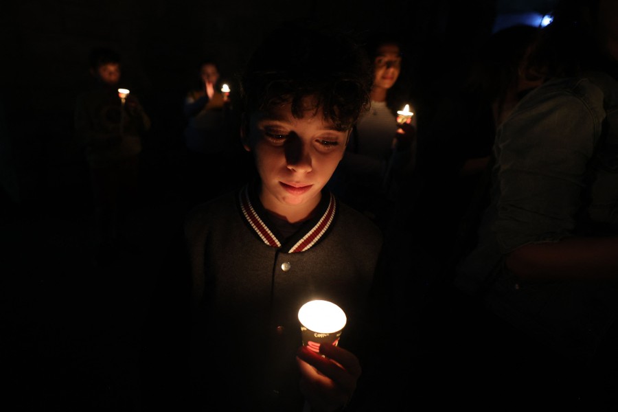 Palestinians hold a candle light vigil for victims in the Gaza Strip, at the Saint Andrew's Episcopal Church in the occupied West Bank town of Ramallah on October 19, 2023, amid the ongoing battles between Israel and the Palestinian group Hamas. -AFP/Jaafar ASHTIYEH