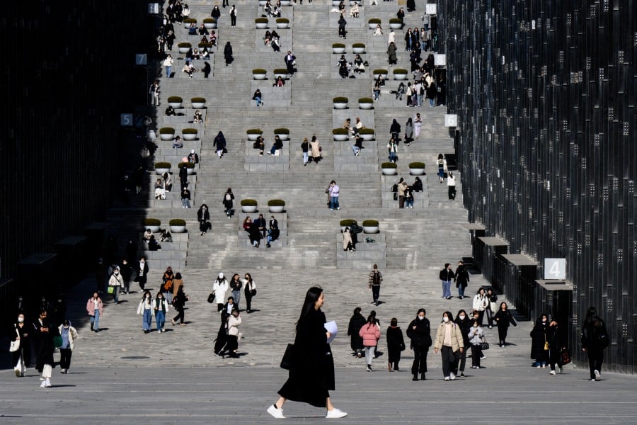 (FILE PHOTO) Students and visitors walk around the campus of Ewha Womans University in Seoul. Despitecriticism, most universities are aiming for a spot in the World University Rankings. -AFP/ANTHONY WALLACE