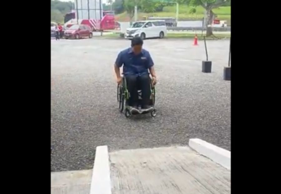 Screen grab of a video of a university professor attempting to use a wheelchair to experience the challenges faced by individuals with disabilities (OKU) ended up falling backward due to the height of the ramp.