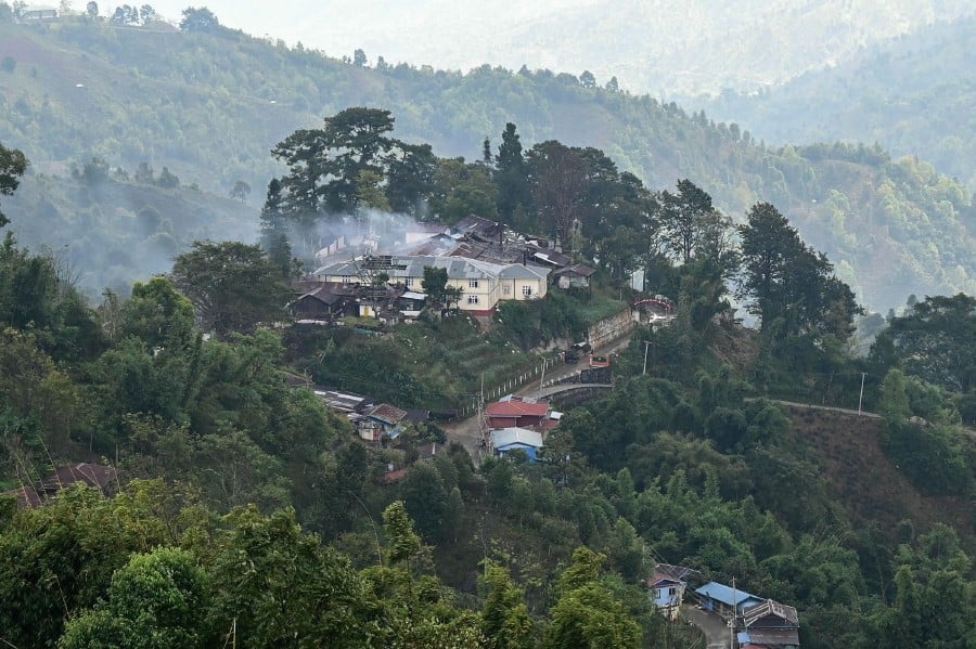 This photo taken on December 13, 2023 shows a burning Myanmar military building amid clashes with ethnic minority armed group Ta'ang National Liberation Army (TNLA) in Namhsan Township in Myanmar's northern Shan State. -AFP PIC