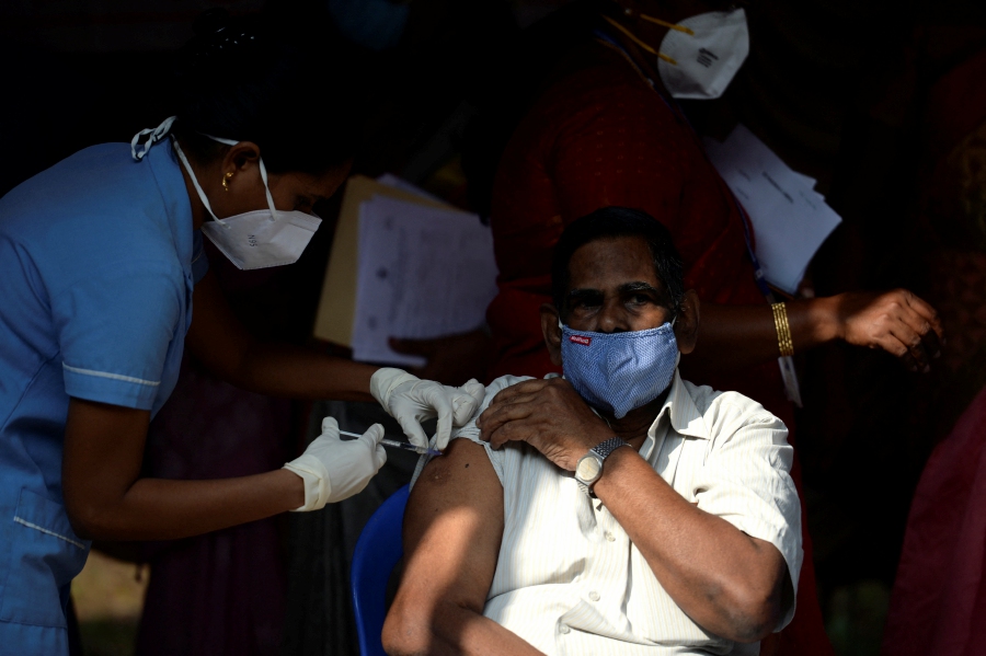 (FILE PHOTO) A health worker inoculates a man with a dose of a vaccine against the Covid-19 coronavirus during a vaccination drive in Chennai. -AFP/Arun SANKAR