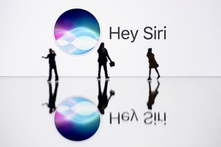 This illustration photograph shows figurines next to a screen displaying a logo of Siri, a digital assistant of Apple Inc. technology company. -AFP/SEBASTIEN BOZON