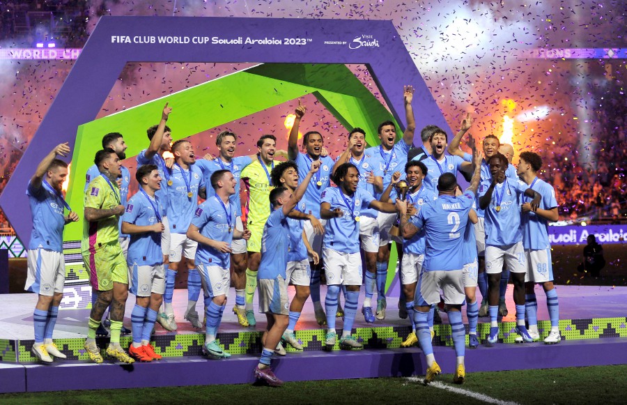 Manchester City players celebrate with the trophy on the podium after winning the Club World Cup final. -REUTERS/Osama Abd El Naby