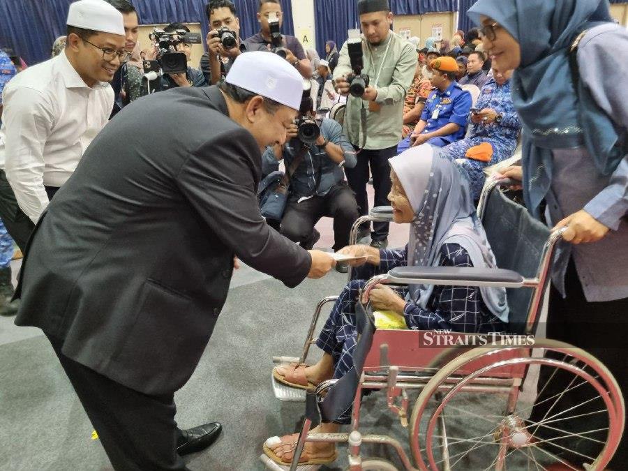 Datuk Mohd Nassuruddin Daud, Menteri Besar, handed out donations to 500 flood victims. Yayasan Sultan Kelantan will assist more than 39,000 Kelantan flood victims. -NSTP/SHARIFAH MAHSINAH ABDULLAH