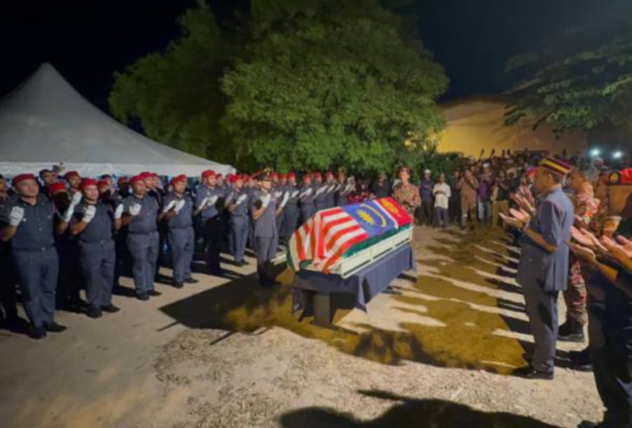 The body of the late Mohd Izwan Illias, a member of the Water Rescue Team, was buried with full ceremonial honours. -PIC COURTESY OF FIRE AND RESCUE DEPT