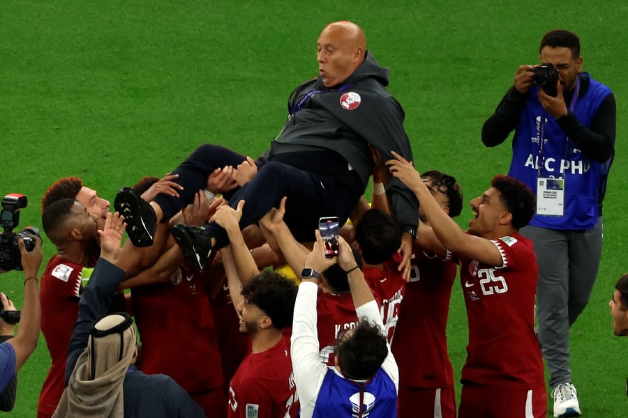 Qatar's players celebrate with their Spanish coach Tintin Marquez after winning the AFC Qatar 2023 Asian Cup final football match between Jordan and Qatar at the Lusail Stadium in Lusail, north of Doha on February 10, 2024. -AFP/KARIM JAAFAR
