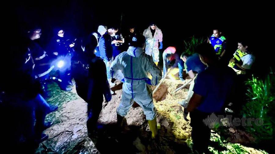 Police excavating the location where a murder victim is buried in Kampung Sg Choh. -PIC COURTESY OF PDRM