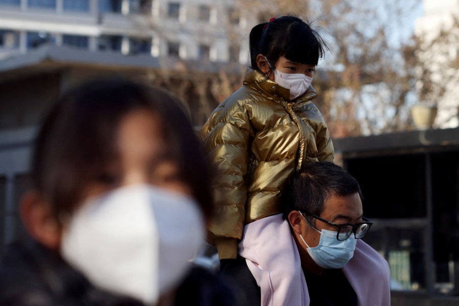 A man carries a child on his shoulders outside a children's hospital in Beijing, China November 24, 2023. REUTERS/Florence Lo