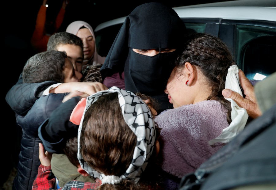 Family members hug released Palestinian prisoner Fatima Amarneh as they welcome her, amid a hostages-prisoners swap deal between Hamas and Israel, near Jenin in the Israeli-occupied West Bank November 25, 2023. -REUTERS/Raneen Sawafta
