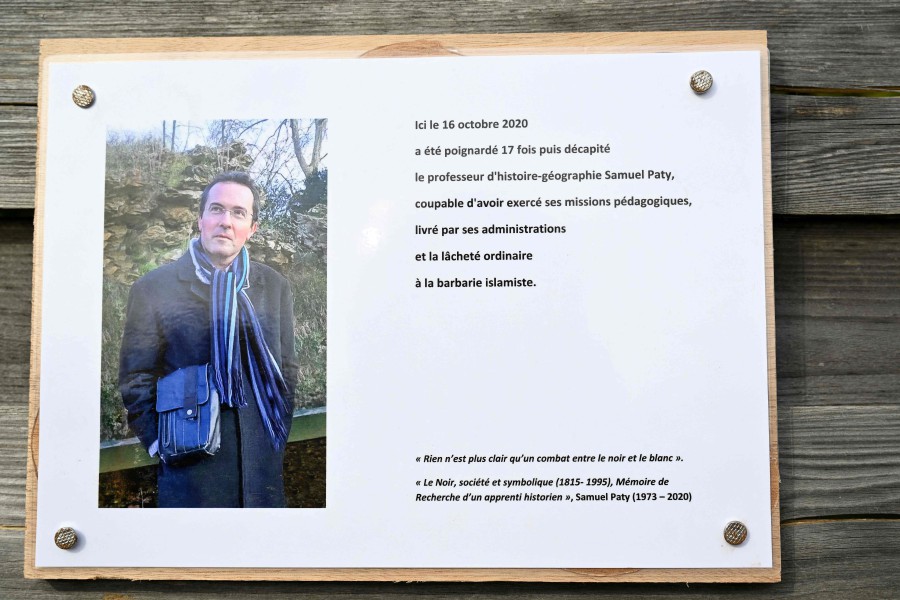 (FILE PHOTO) A photograph taken on October 16, 2023 shows a commemorative plaque for slain teacher Samuel Paty (portrait) near the Bois d'Aulne school in Conflans-Sainte-Honorine, outside Paris. Six teenagers will be tried by the juvenile court from November 27, 2023 in the case of Samuel Paty, a teacher who was beheaded on October 16, 2020 by a radicalised young man. -AFP/Bertrand GUAY