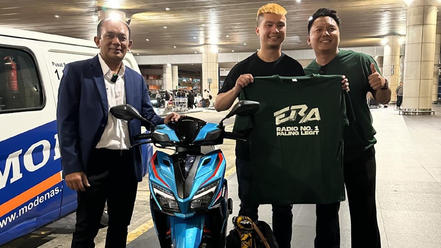 Derrick Gan, now famous for selling his motorcycle to fund his trip to Qatar in support of Harimau Malaya at the 2023 Asian Cup, was greeted with a brand new motorcycle gifted by Modenas at the KLIA. -PIC COURTESY OF MODENAS