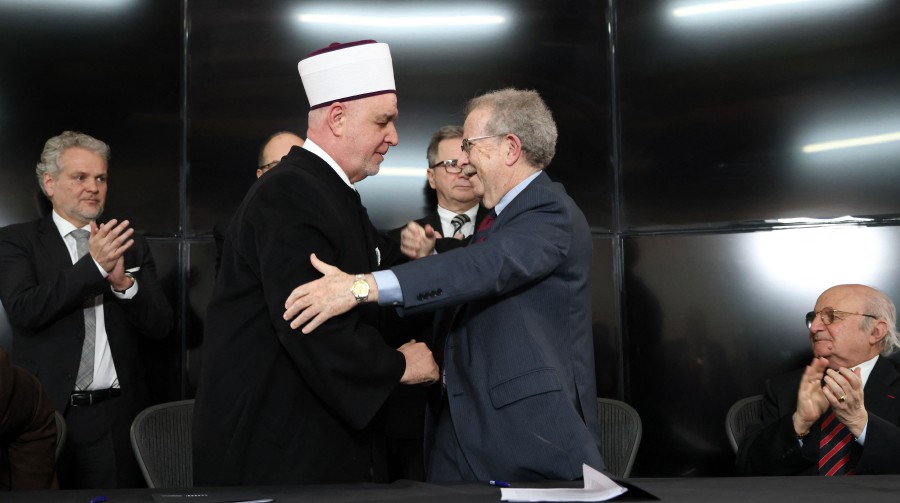 The President of the World Federation of Bergen-Belsen Associations and American lawyer, Menachem Rosensaft (right) and the religious leader of Bosnian Muslims, Husein Kavazovic (left) embrace after signing a "Jewish-Muslim Initiative for Peace" at the Srebrenica Genocide Memorial Centre in Srebrenica  on International Holocaust Remembrance Day, as deadly fighting rages in the Gaza Strip. -AFP PIC