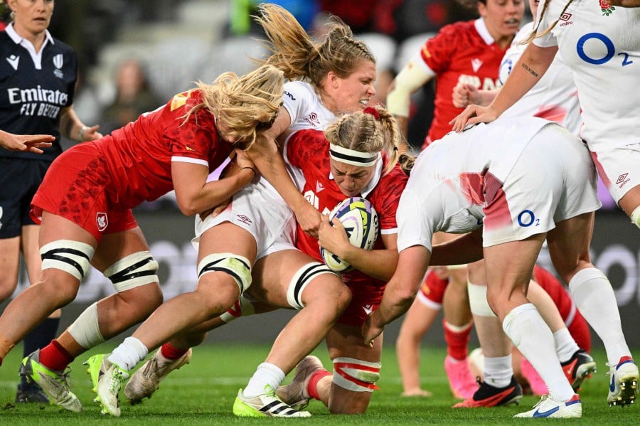 Canada's Courtney Holtkamp (centre) attempts to break through a tackle during the WXV 1 women’s rugby match between England and Canada at Forsyth Barr Stadium in Dunedin. -AFP/BLAKE ARMSTRONG