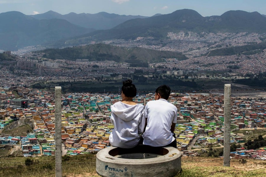 Tourists look at the Ciudad Bolivar neighbourhood during a tour in Bogota. -AFP/Alejandro MARTINEZ