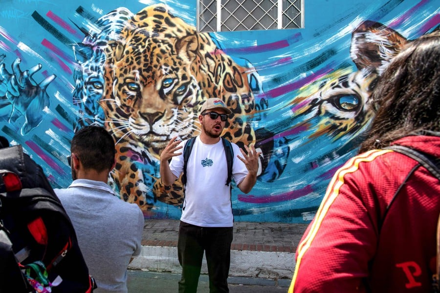 Tourist guide May Rojas talks with tourists during a tour of the Ciudad Bolivar neighbourhood in Bogota. -AFP/Alejandro MARTINEZ