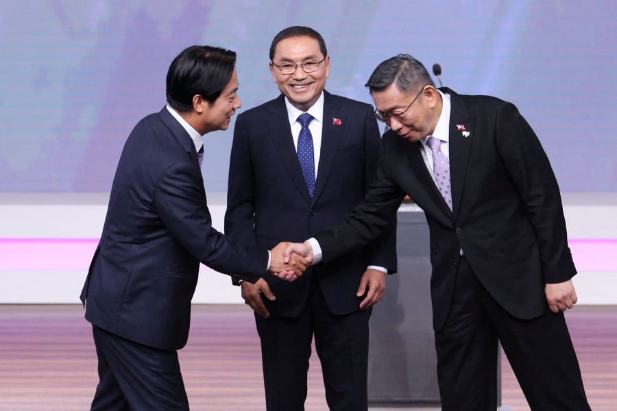 Lai Ching-te (left), presidential candidate from the ruling Democratic Progressive Party (DPP), shakes hands with Ko Wen-je (right), presidential candidate from the opposition Taiwan People’s Party (TPP), as Hou Yu-ih (centre), presidential candidate from the main opposition Kuomintang (KMT), looks on during a debate in Taipei on December 30, 2023. -AFP/Huang Shih-chi