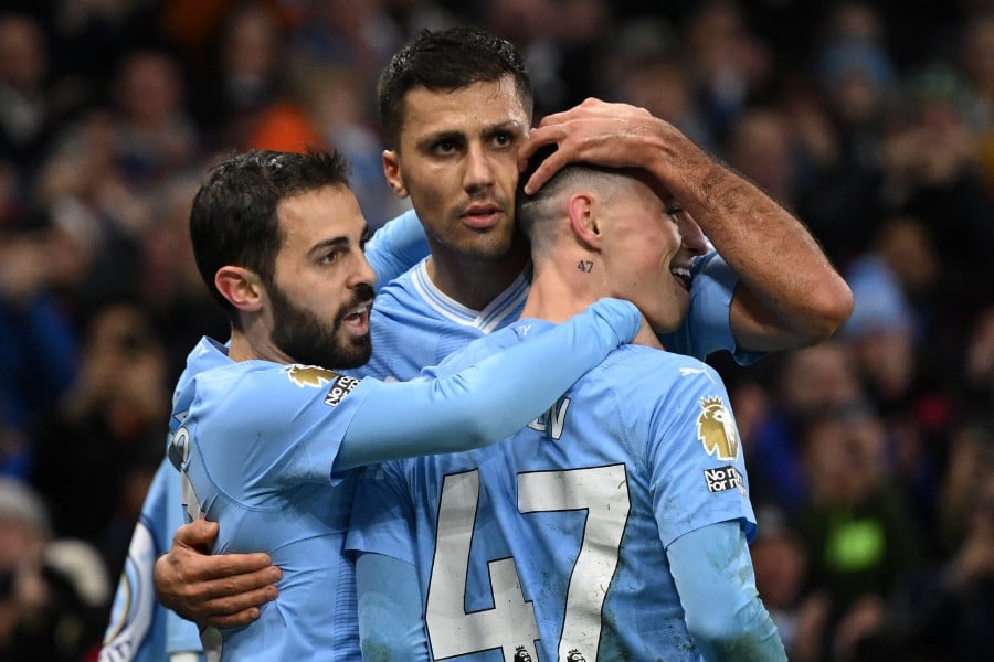 Manchester City's Spanish midfielder #16 Rodri (centre) celebrates with teammates after scoring the opening goal of the English Premier League football match between Manchester City and Sheffield United at the Etihad Stadium in Manchester, north west England, on December 30, 2023. -AFP/Oli SCARFF