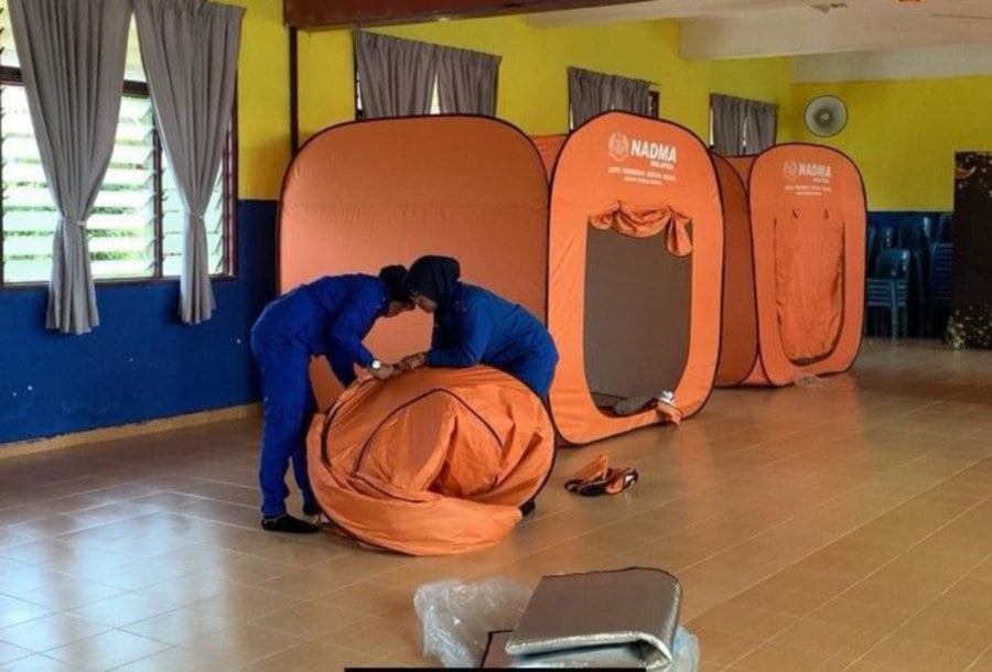 Civil Defence Force (APM) staff are preparing to close the SK Bukit Gemuruh flood relief centre in Bera. -PIC COURTESY FOR APM 